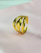 Orelia adjustable anti-tarnish gold plated stainless steel ring featuring a smooth, high-polish multi-row wave dome design on a soft pink satin background.
